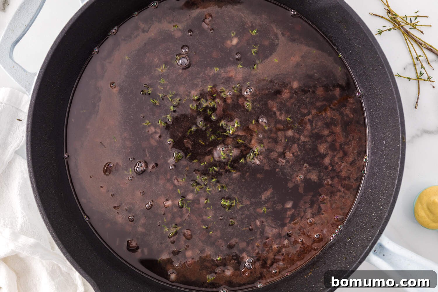Port wine bubbling and reducing in the skillet with sautéed shallots, forming the base of the sauce.