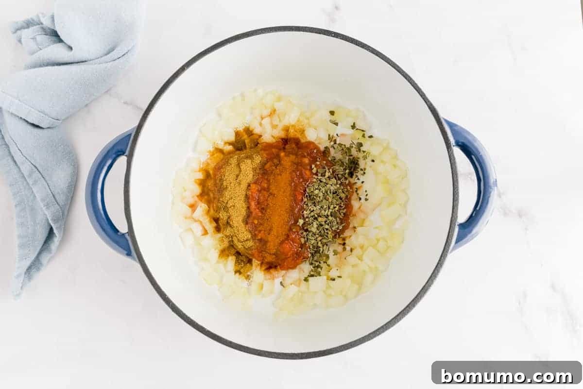 Spices on top of onions in a large pot.