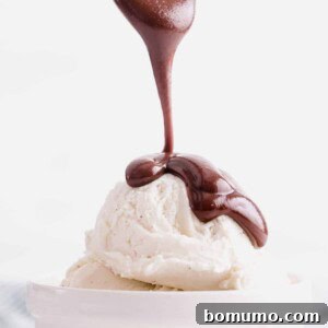 Delicious hot fudge sauce being drizzled over ice cream, ready to be served.