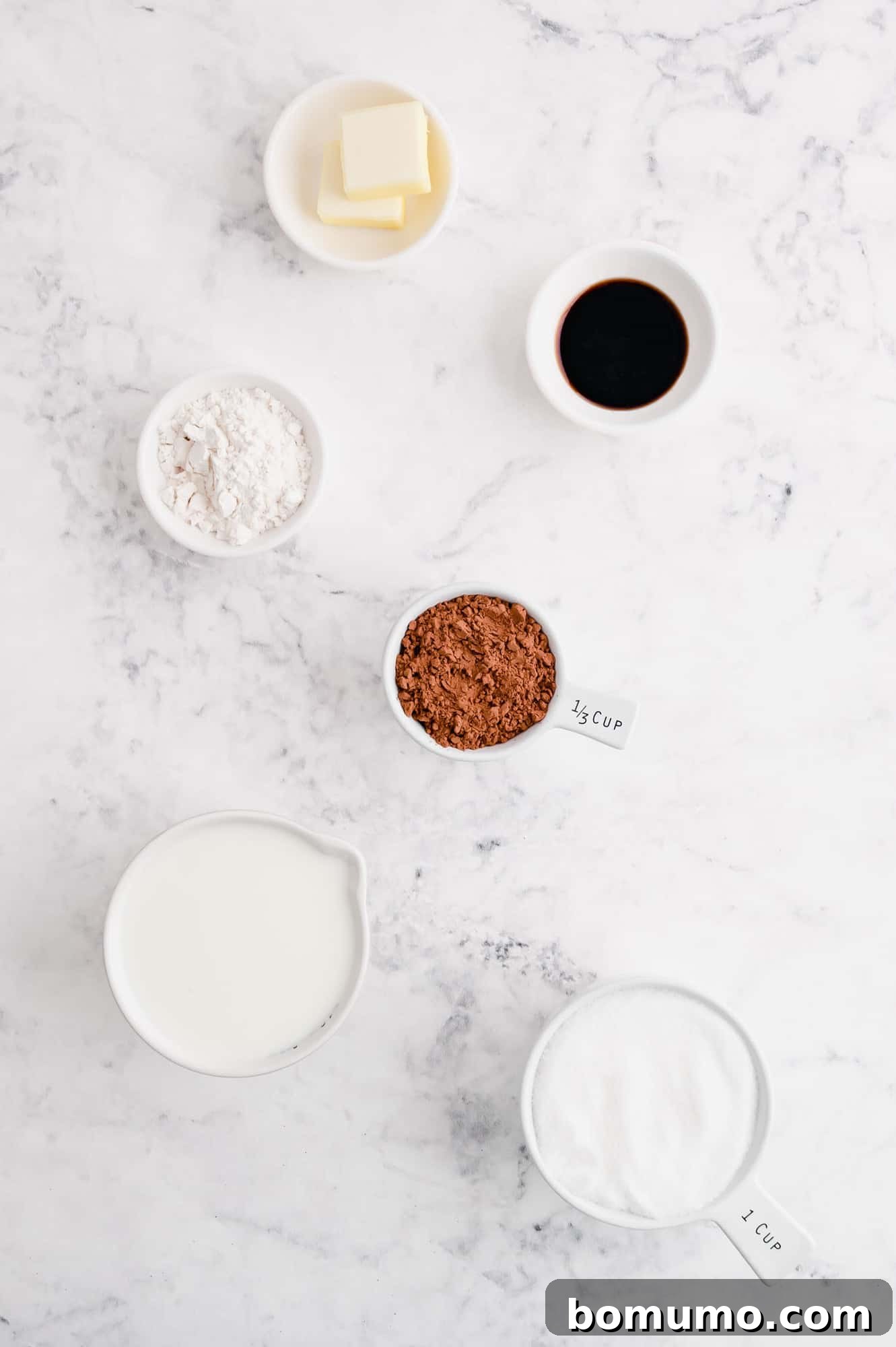 An overhead shot showcasing all the simple ingredients required for homemade hot fudge, arranged neatly on a surface.