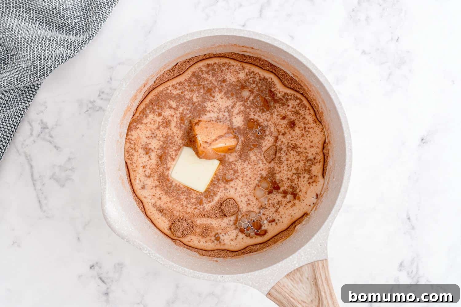 Hot fudge sauce in a saucepan before it has come to a boil, showing its liquid state.