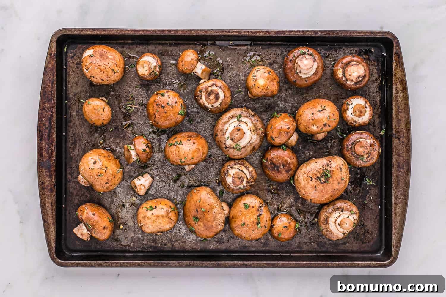 Umami Roasted Mushrooms 6 Cleaned and seasoned mushrooms neatly spread in a single layer on a baking sheet, ready for the oven to begin the roasting process.