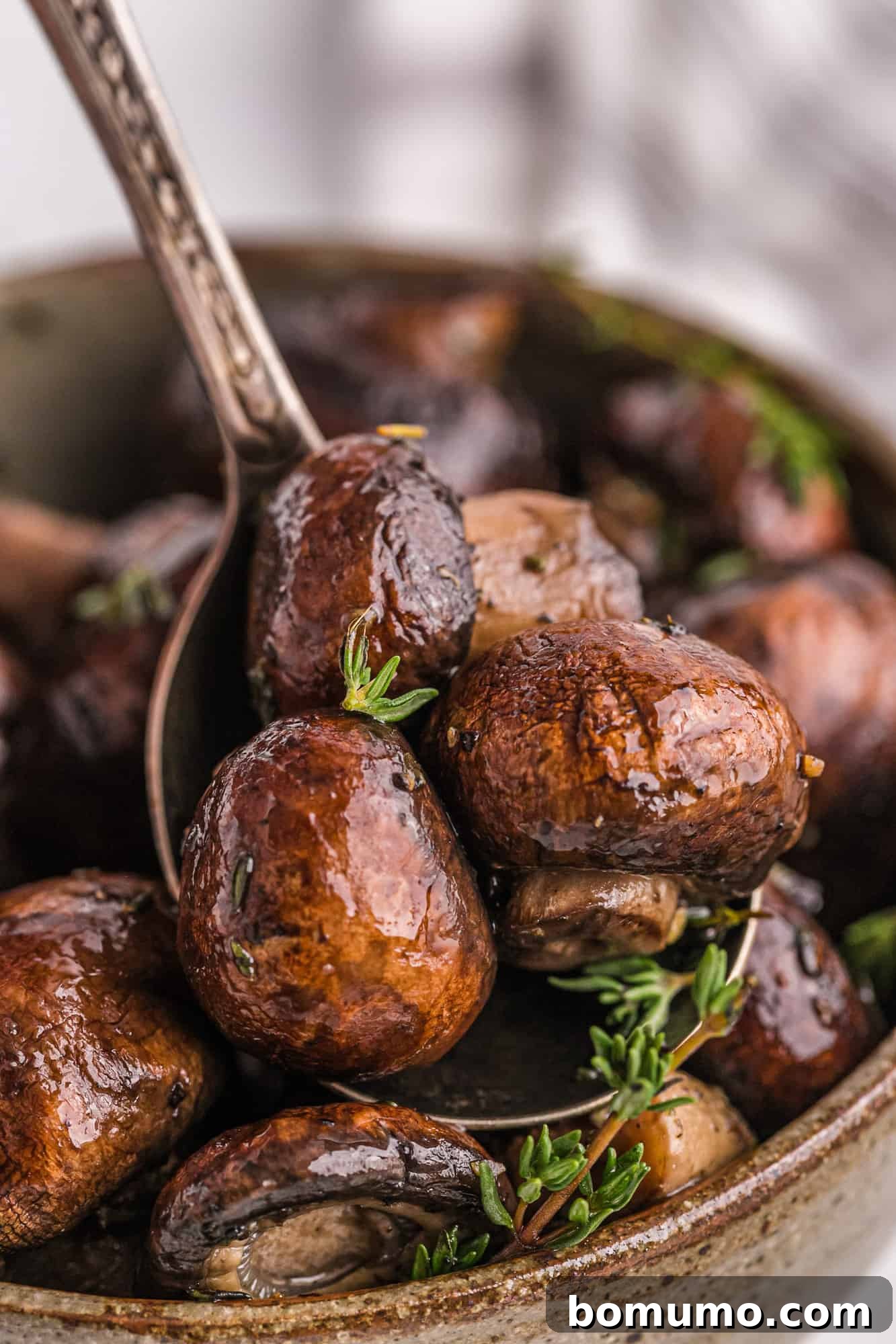 Umami Roasted Mushrooms 8 A serving spoon filled with warm, perfectly roasted mushrooms, highlighting their tender texture and delicious coating.