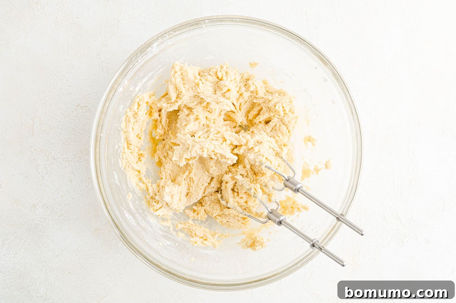 Cookie dough in a mixing bowl, perfectly formed and ready to be pressed into the pan.