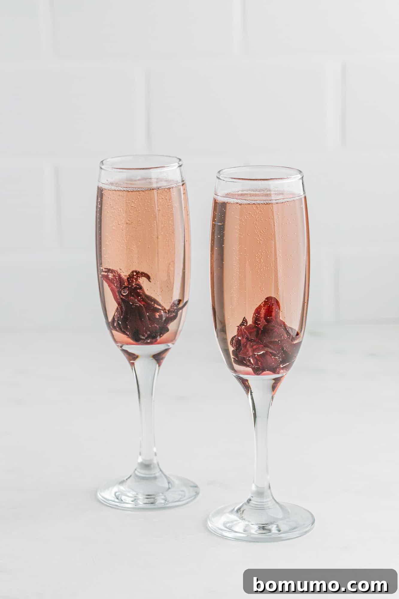 Two mimosas with hibiscus flowers in them, sparkling with elegance.