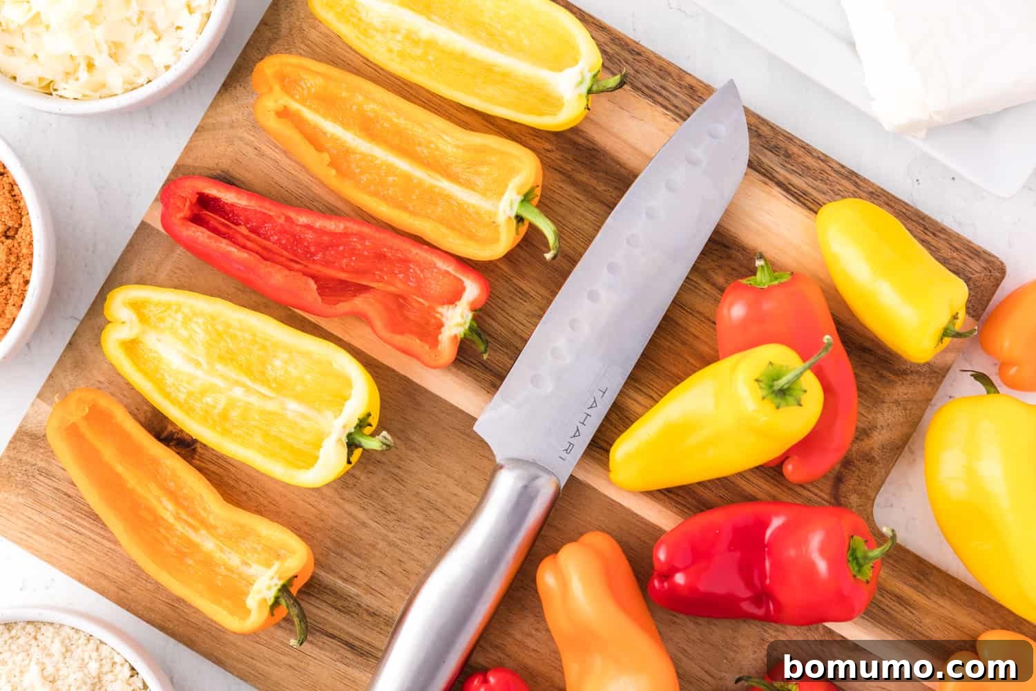 Mini sweet peppers precisely cut in half lengthwise, ready for stuffing.