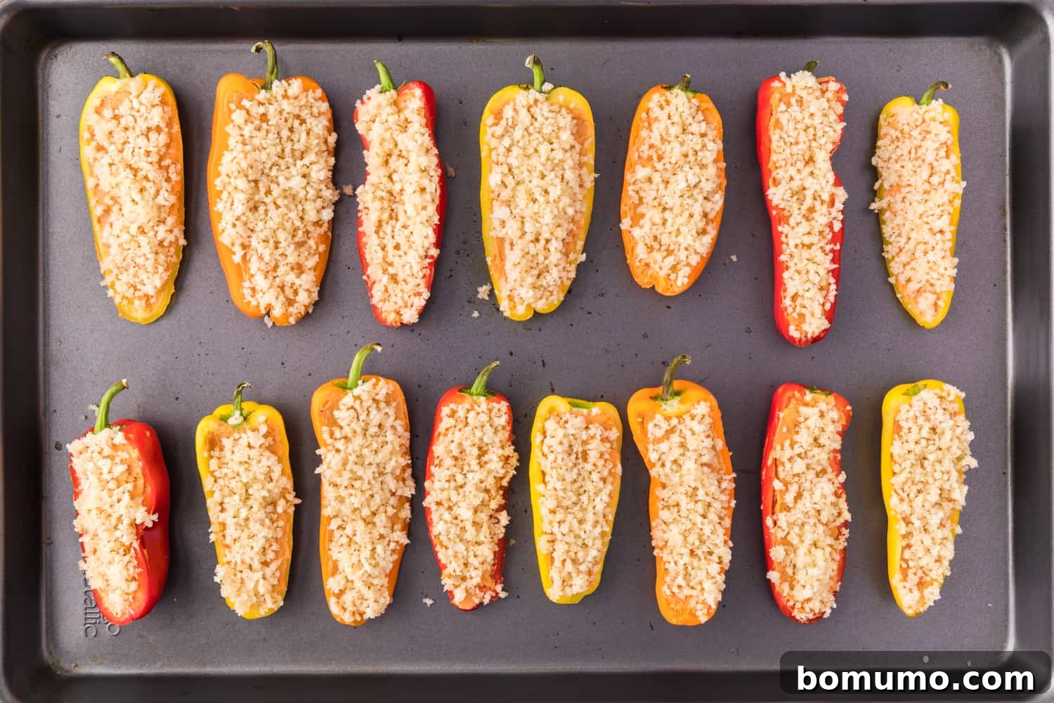 Stuffed mini peppers now topped with the buttery panko bread crumb mixture, ready for baking.