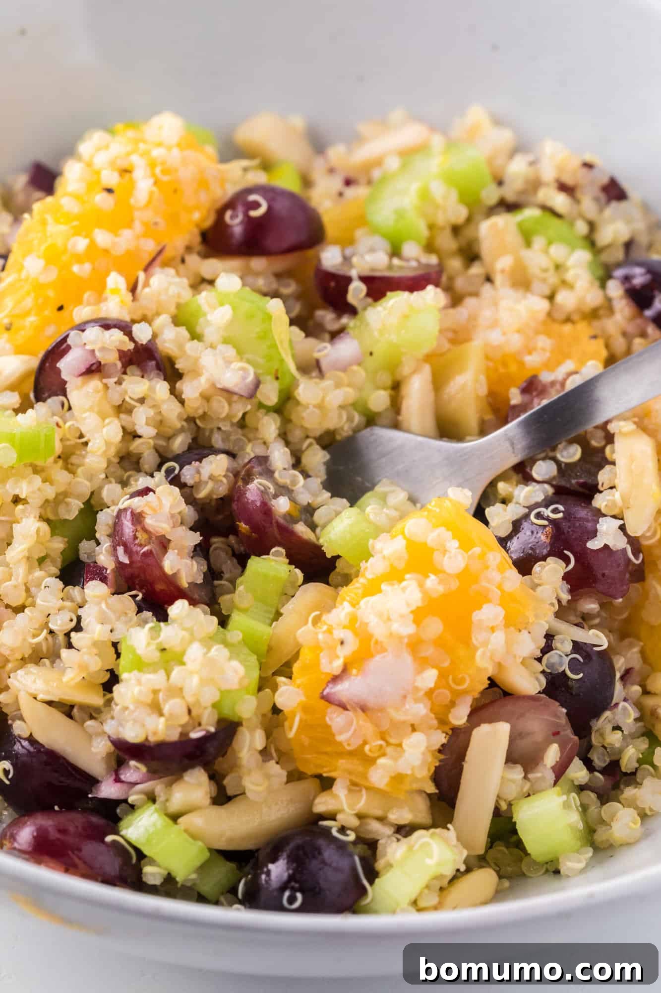 A close-up shot of the quinoa salad on a fork, showcasing the individual ingredients and inviting texture, ready for a bite.