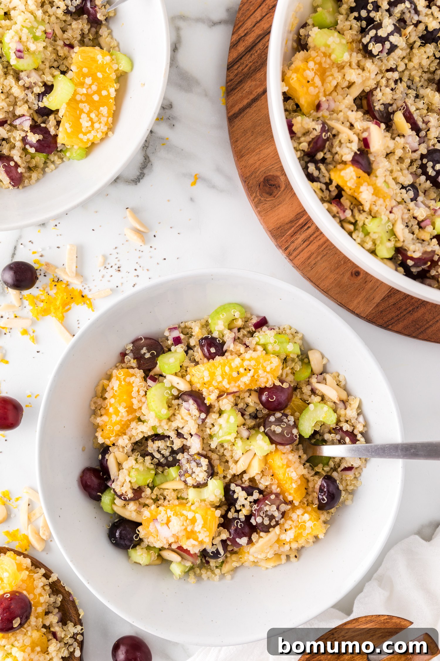 A small individual serving bowl of quinoa salad sits beside a larger communal bowl, highlighting its versatility for both personal enjoyment and sharing.