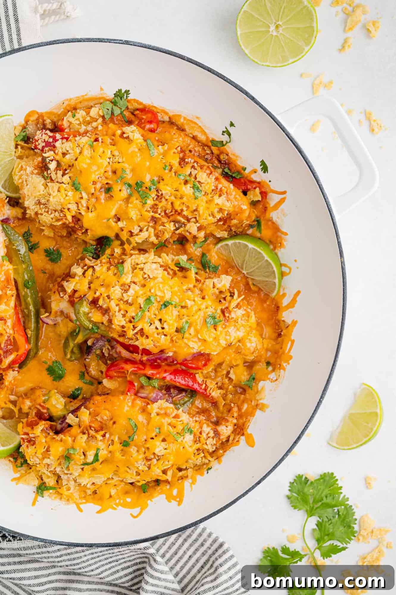 Overhead view of fajita stuffed chicken in a round baking dish, garnished with fresh cilantro.