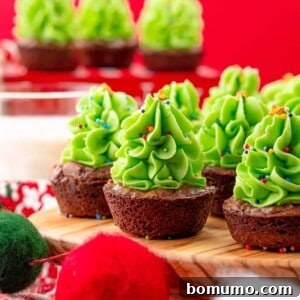 Christmas tree mini brownie bites, with green frosting resembling trees, garnished with festive sprinkles.