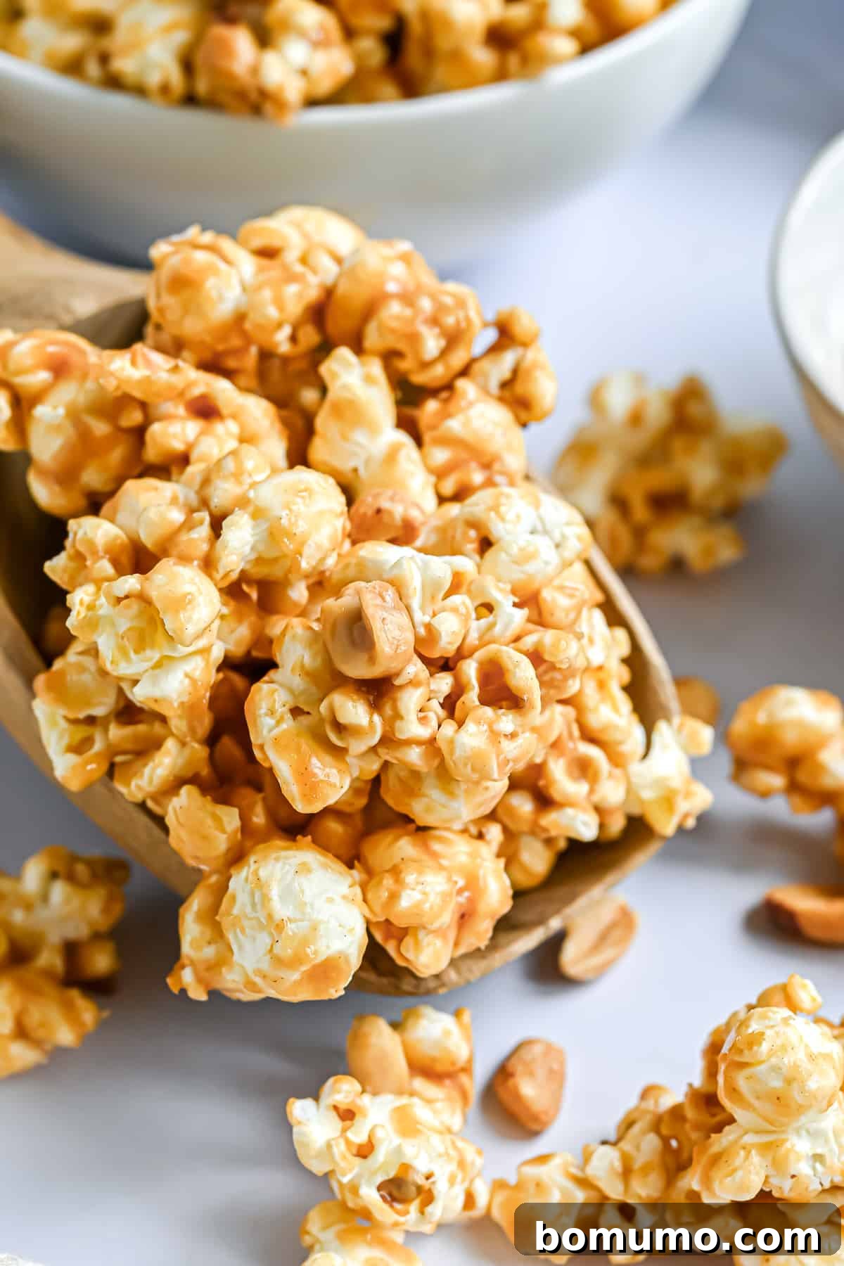 Delicious peanut butter popcorn piled high on a large wooden spoon, ready for snacking.