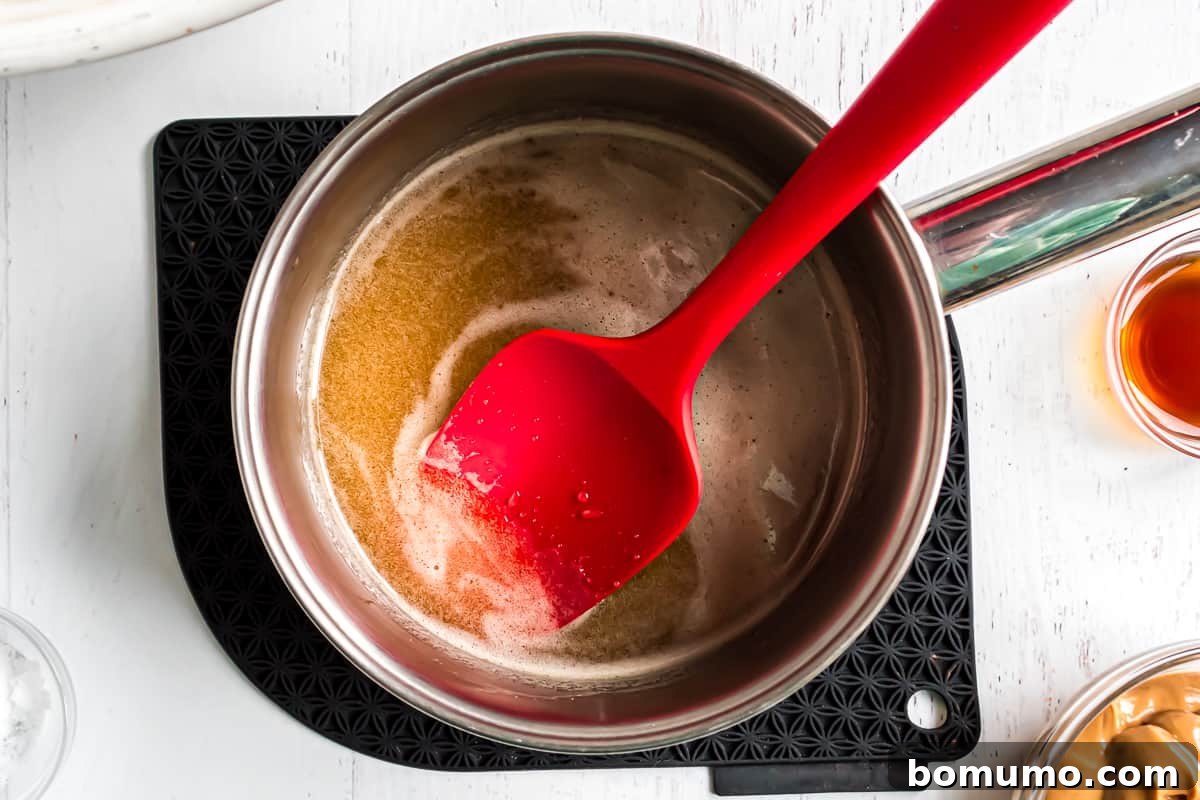 The honey and sugar mixture simmering in a saucepan until fully dissolved and smooth.