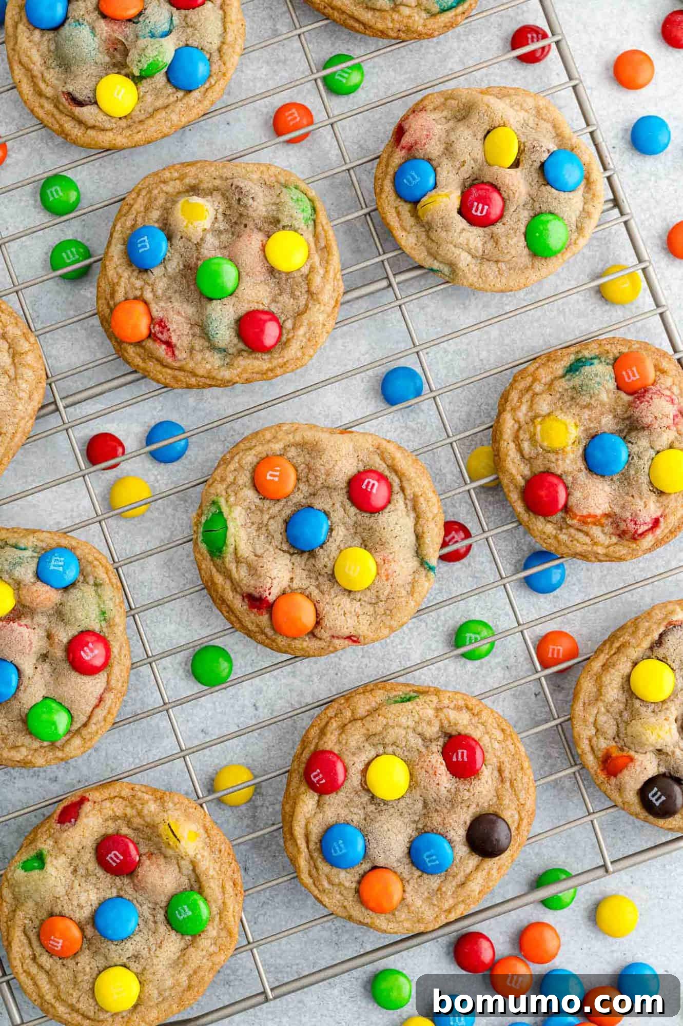 Ultimate M M Cookies 3 Freshly baked M&M cookies cooling on a wire rack, steam gently rising, promising a delightful treat.