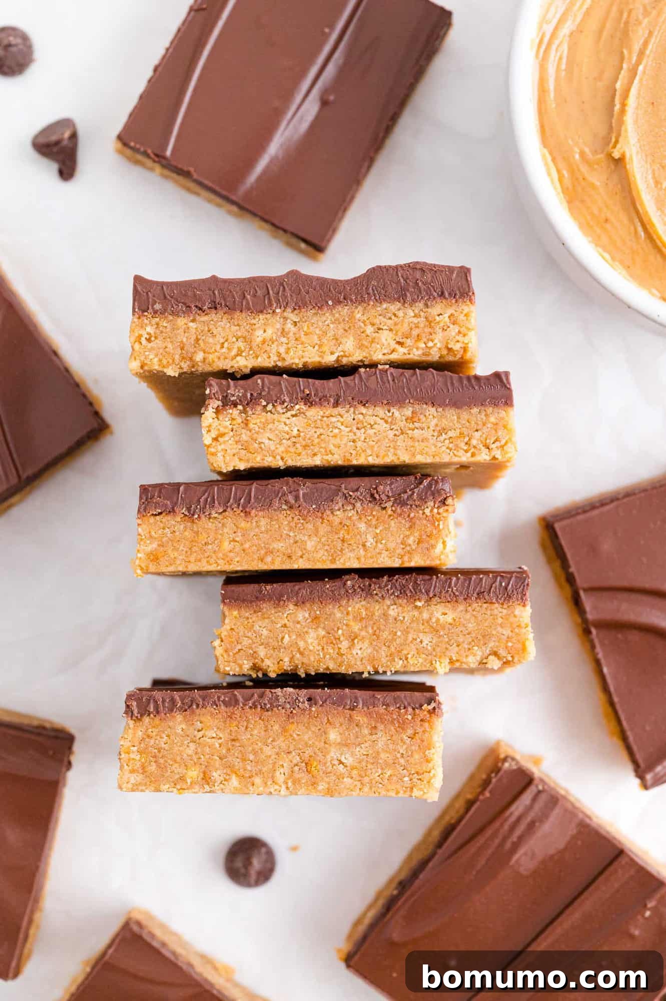 Stacked layers of no-bake peanut butter bars, showing the rich chocolate and creamy peanut butter base.