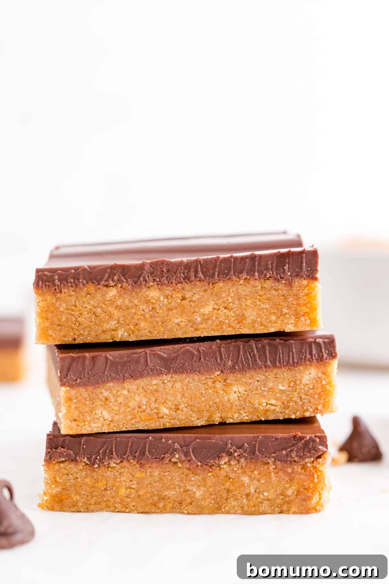 A stack of three homemade no-bake Reese's peanut butter bars, highlighting the distinct layers.