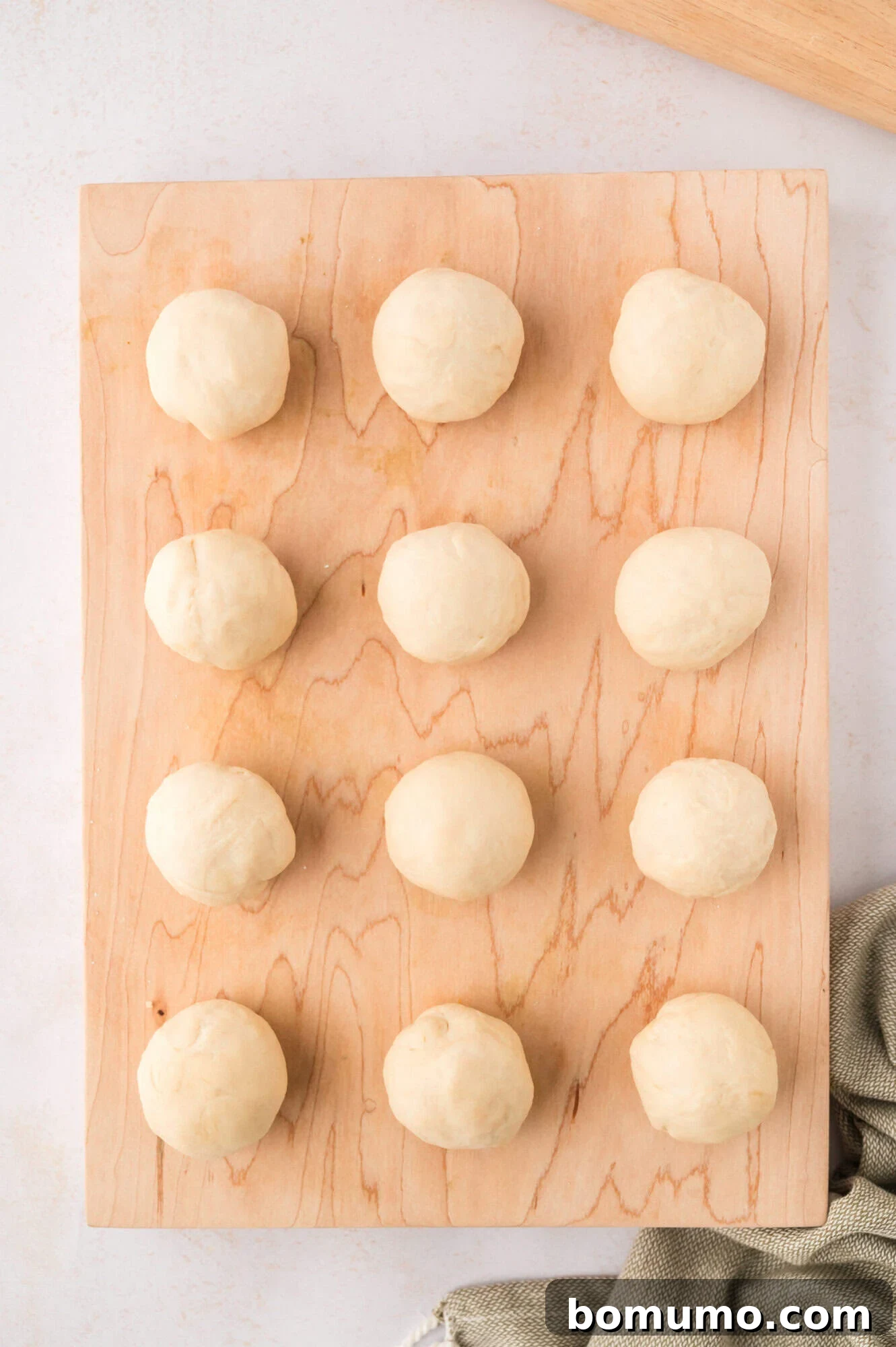 Tortilla dough separated into twelve equal balls, ready for rolling.