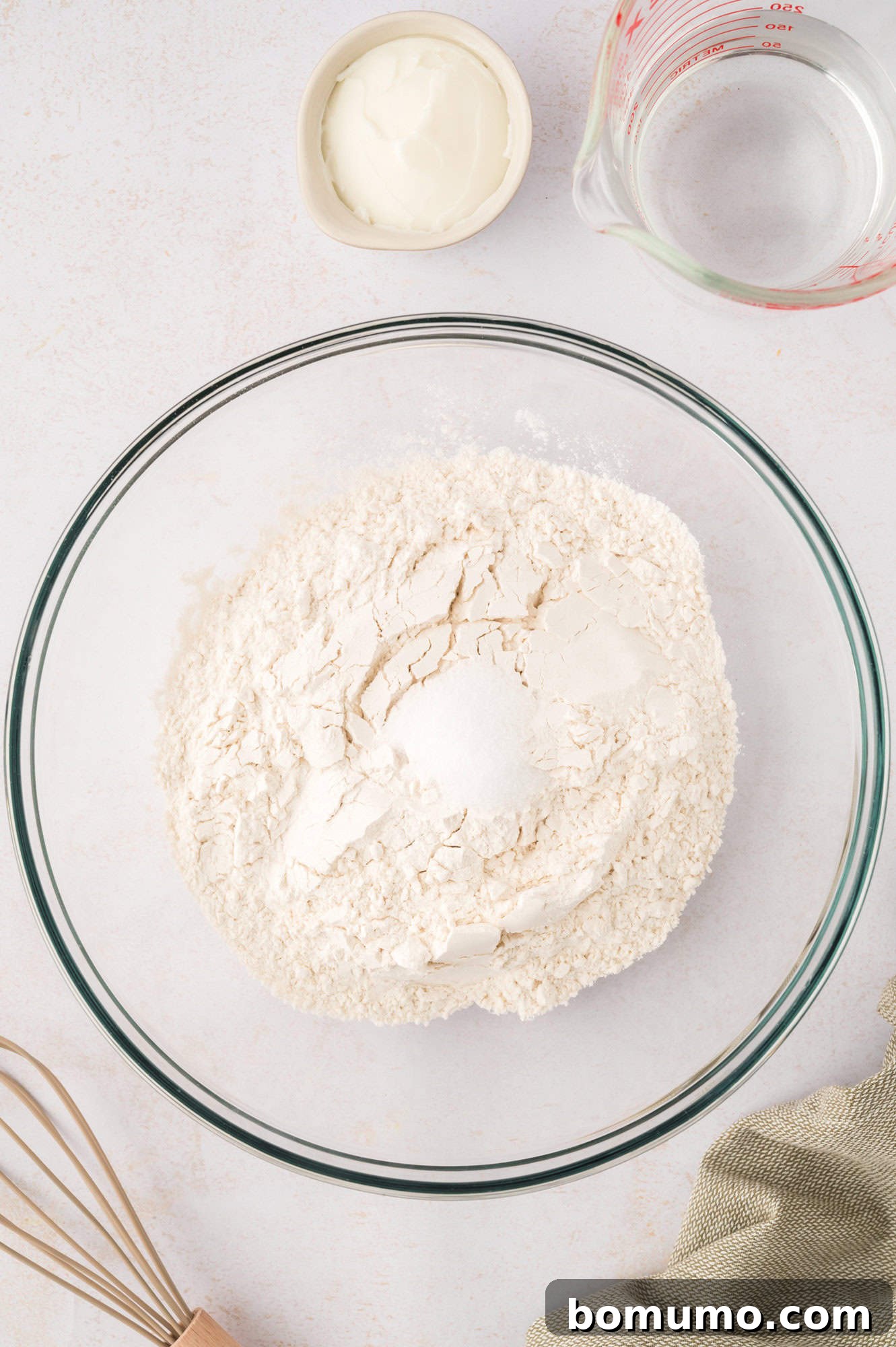Dry ingredients, flour and salt, waiting to be mixed together in a bowl.