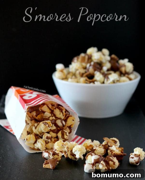 Campfire Crunch Popcorn 2 A bag of s'mores popcorn tipped over, spilling delicious chocolate, marshmallow, and graham cracker coated popcorn onto a surface. A white bowl of s'mores popcorn sits in the background, ready for sharing. Text overlay reads,