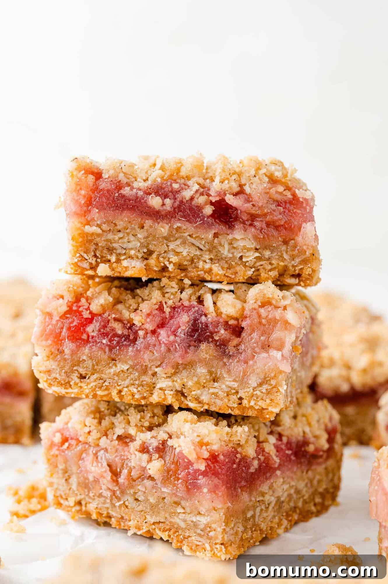 A charming stack of three golden-brown rhubarb crumb bars, ready to be enjoyed.