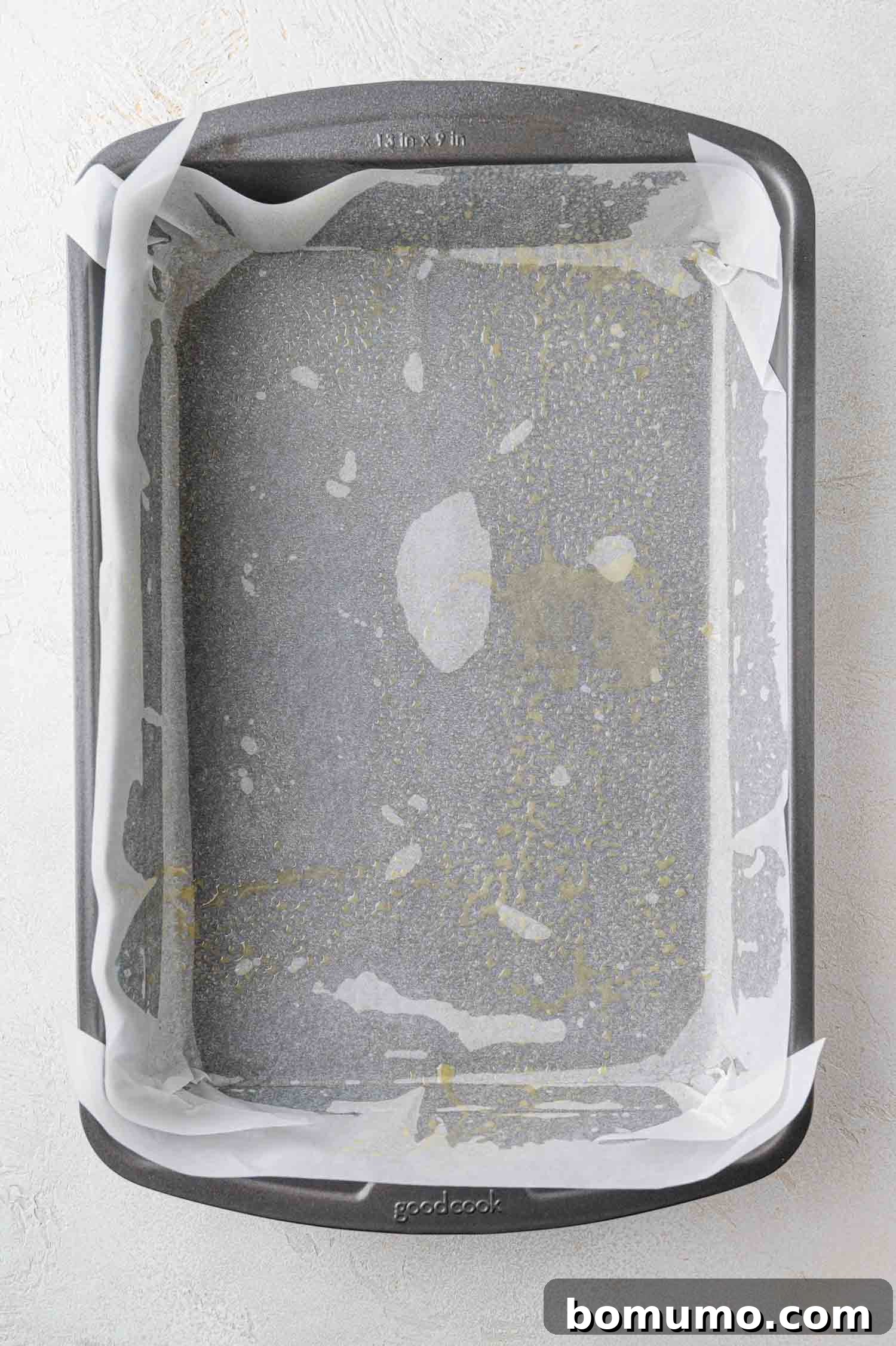 Baking dish meticulously prepared with parchment paper and nonstick cooking spray.