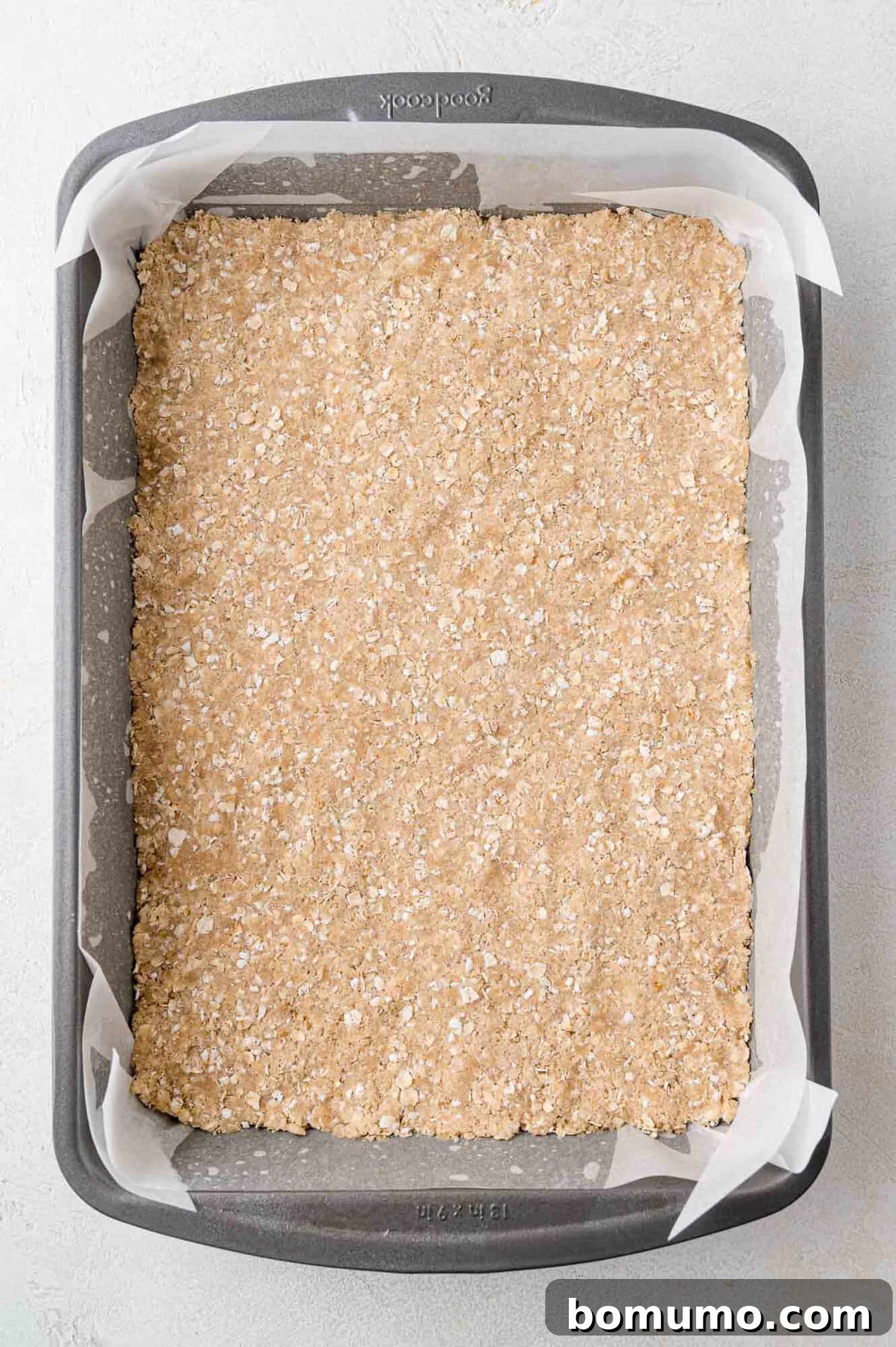 The crumb crust firmly pressed into the baking pan, ready for its initial bake.