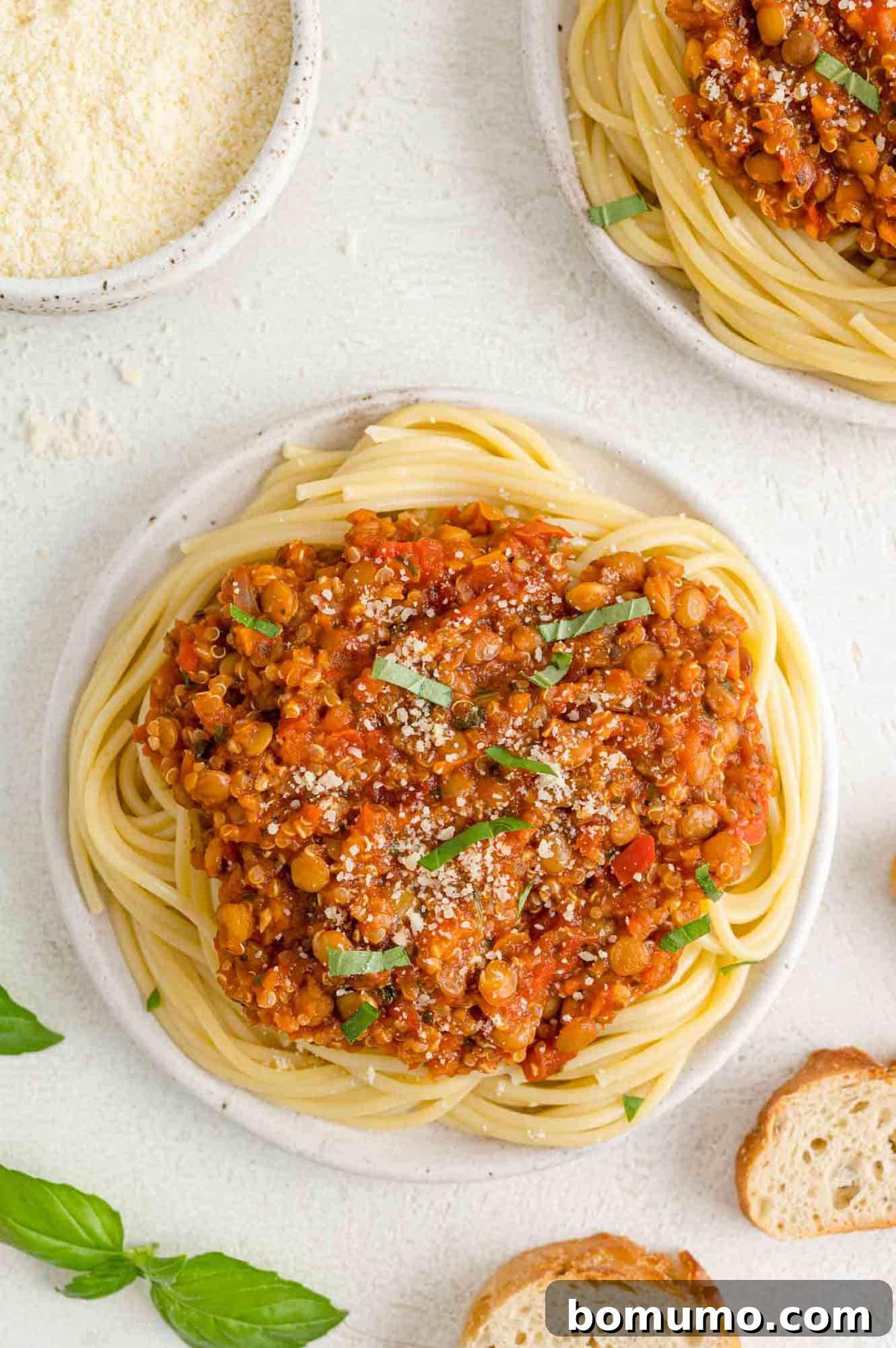 Vegan bolognese on spaghetti, garnished with fresh basil.