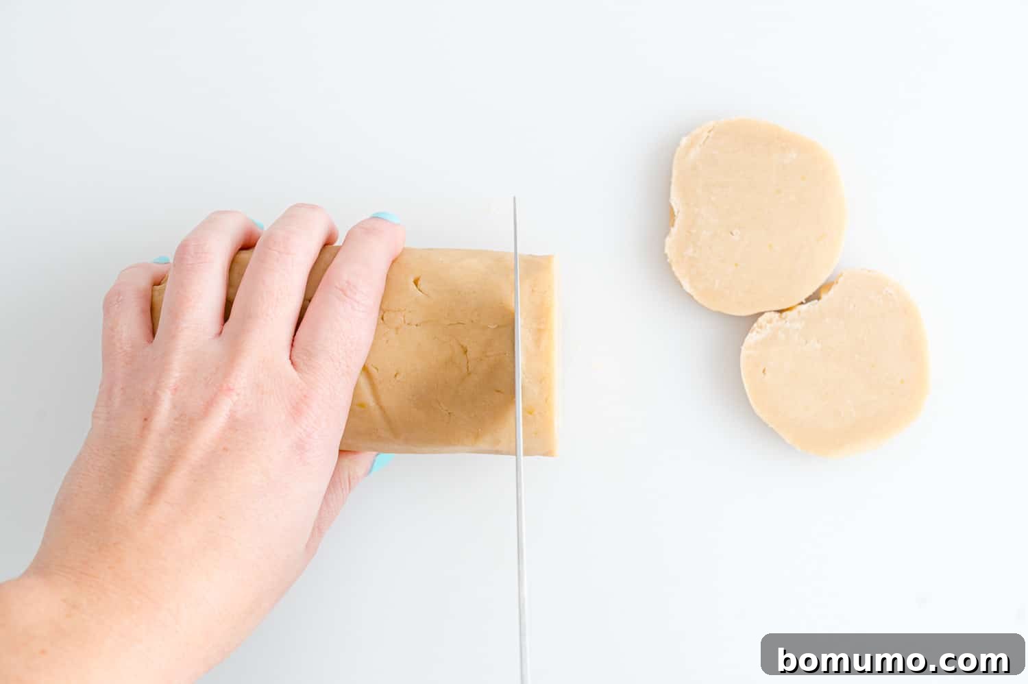 Roll of cookie dough being cut.