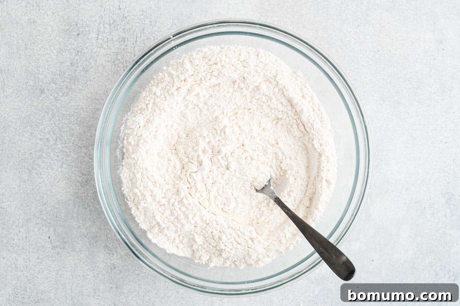 Dry ingredients mixed together in a glass mixing bowl.