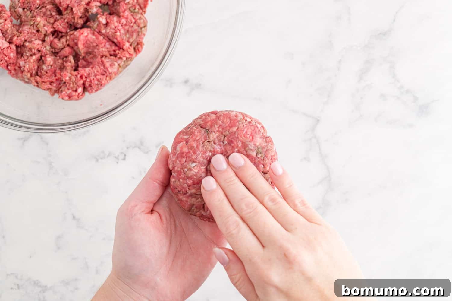 Burger being formed by hand.