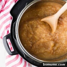 Overhead view of applesauce in an Instant Pot with wooden spoon.