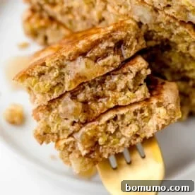 Apple quinoa pancakes on a fork with syrup.