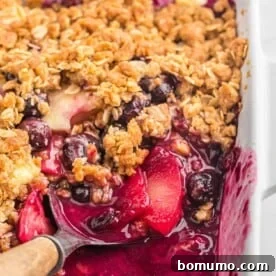 Apple blueberry crisp with some scooped out to show filling.