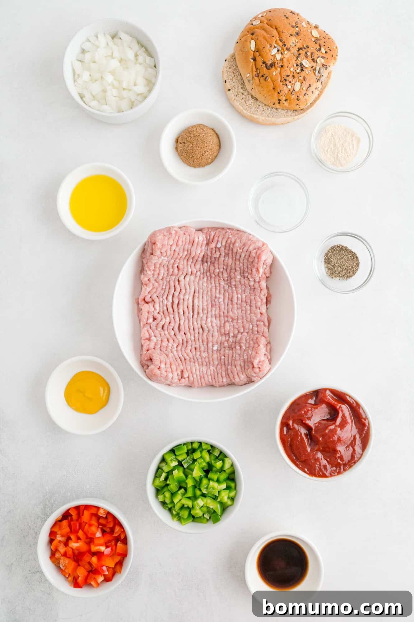 An overhead view of all the essential ingredients for homemade sloppy Joes, including ground turkey, colorful bell peppers, and various sauce components, neatly arranged before cooking.