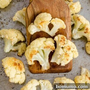Roasted cauliflower on a wooden spatula, ready to be served.