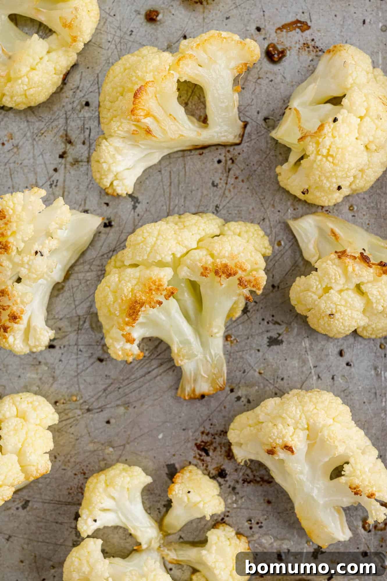 Perfectly Crispy Roasted Cauliflower 3 Cauliflower florets arranged on a sheet pan, ready for roasting.