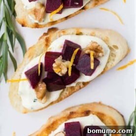 Overhead photograph of ruby red beets and creamy goat cheese on crispy crostini, garnished with fresh herbs.