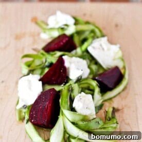 An elegant asparagus ribbon salad with vibrant beets and creamy burrata cheese, perfect for a special occasion.
