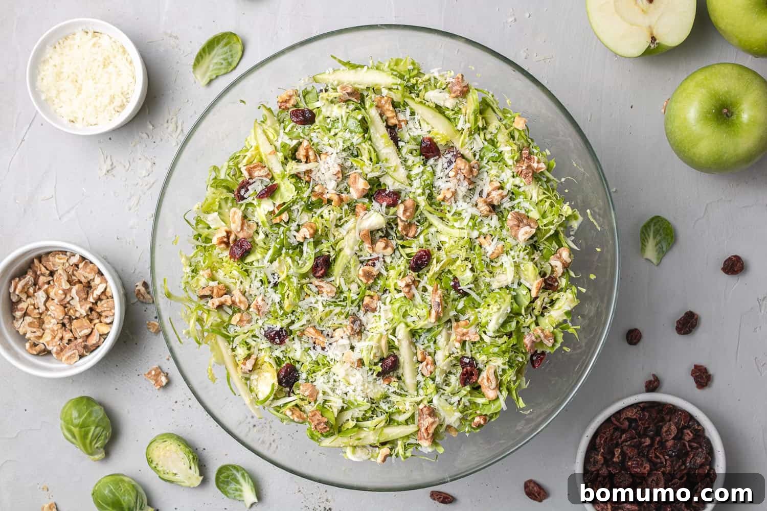 Finished Brussels sprouts salad, generously topped with grated cheese and toasted walnuts, ready to be served.
