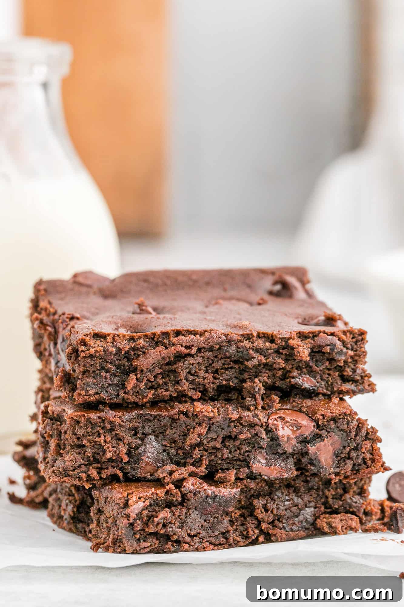 Three black bean brownies stacked up, showcasing their rich, dark texture.