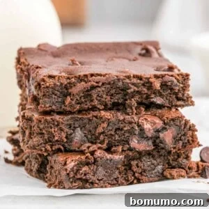Three black bean brownies stacked up, showcasing their rich, dark texture.