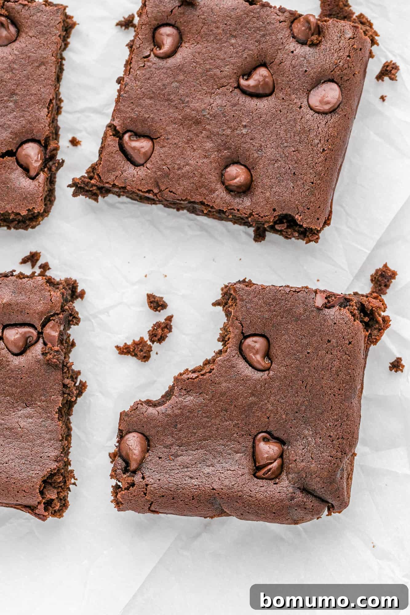 A perfectly baked black bean brownie with a bite taken out, revealing its dense, moist interior.