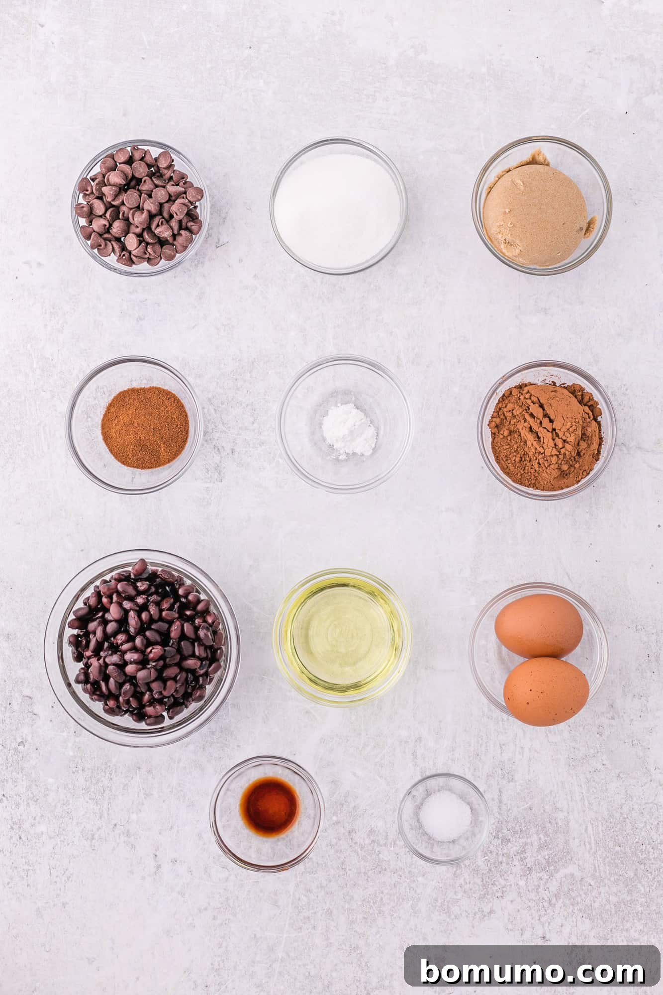 All the dry and wet ingredients laid out on a table, ready for making black bean brownies.
