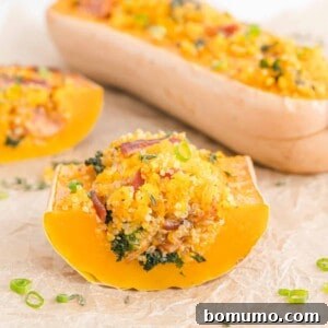 Stuffed butternut squash cut to show filling of quinoa, bacon, kale.