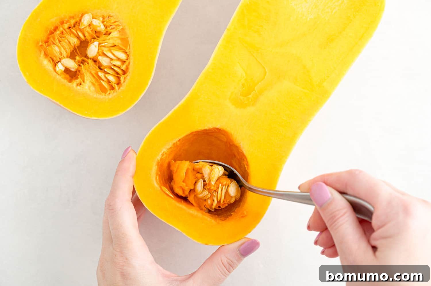 Seeds being scooped out of squash.