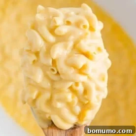 A generous scoop of creamy crockpot mac and cheese, perfect for a comforting meal.