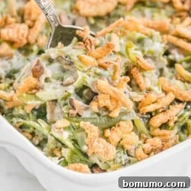 Homemade green bean casserole with a crispy topping in a white baking dish.