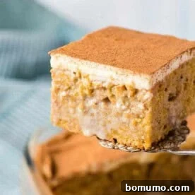 A delectable pumpkin poke cake being scooped from a baking dish, revealing its moist, infused layers.