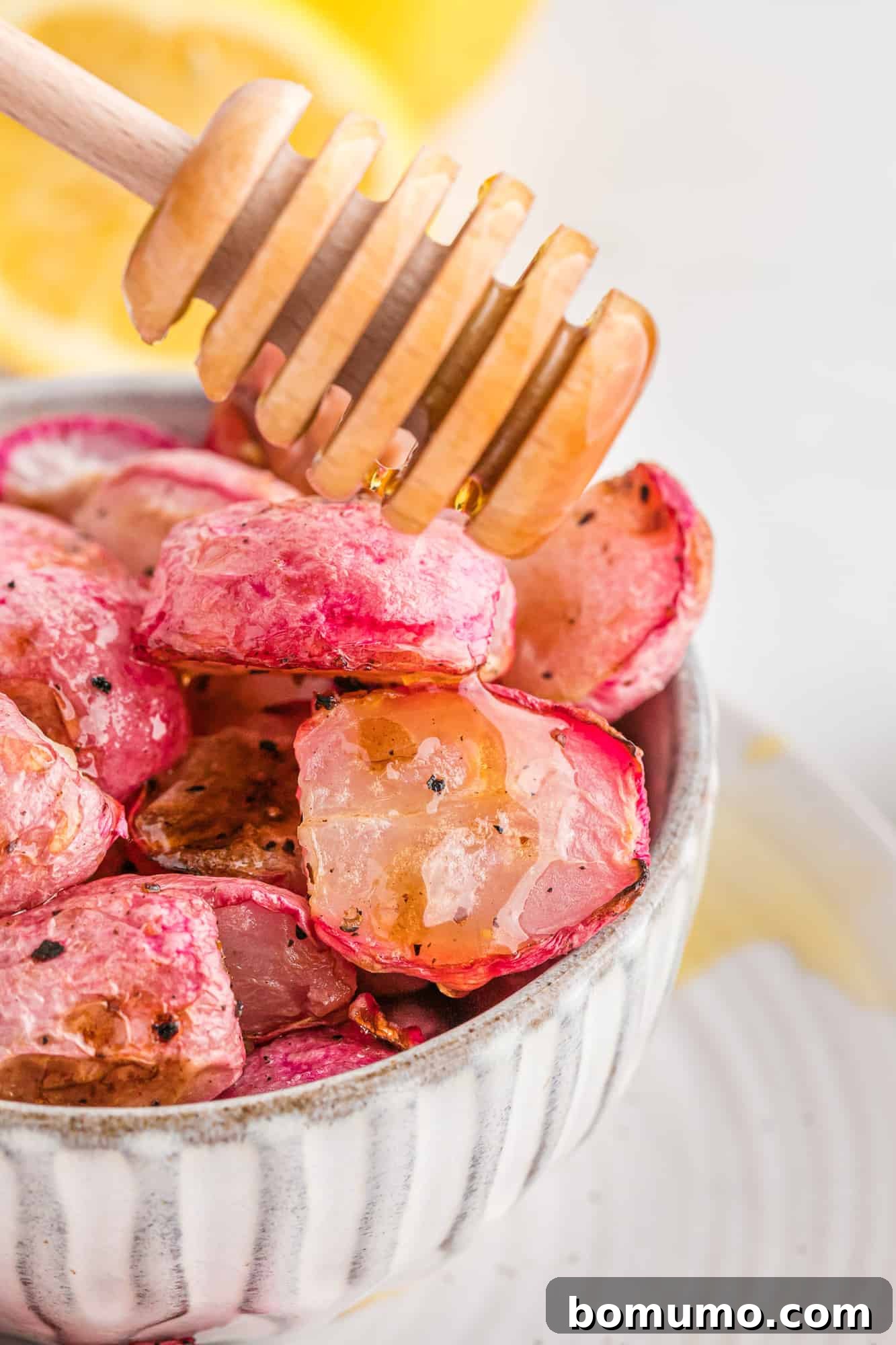 Roasted radishes being drizzled with honey, highlighting their appealing texture.