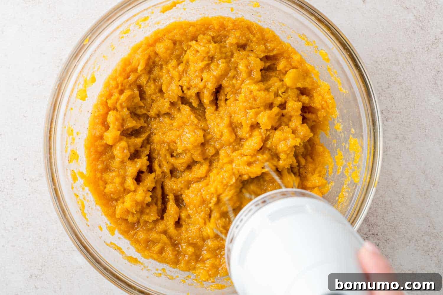 Electric mixer blending butternut squash mash.